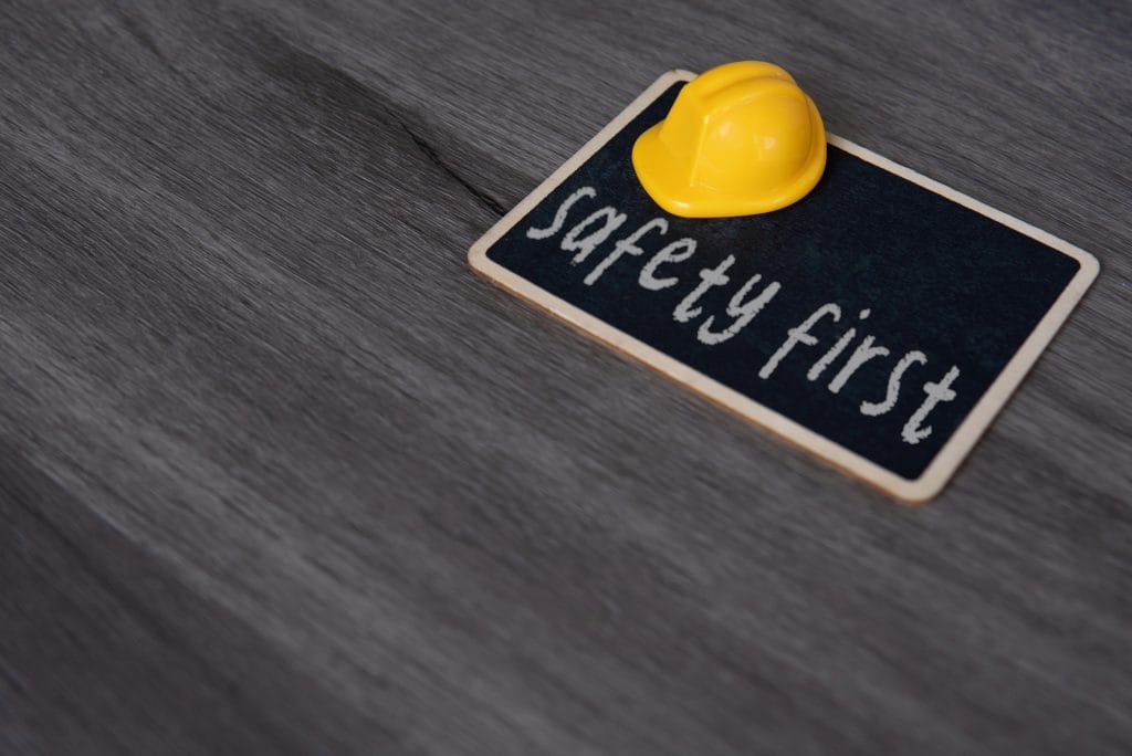 Yellow hard hat and chalkboard with text SAFETY FIRST.
